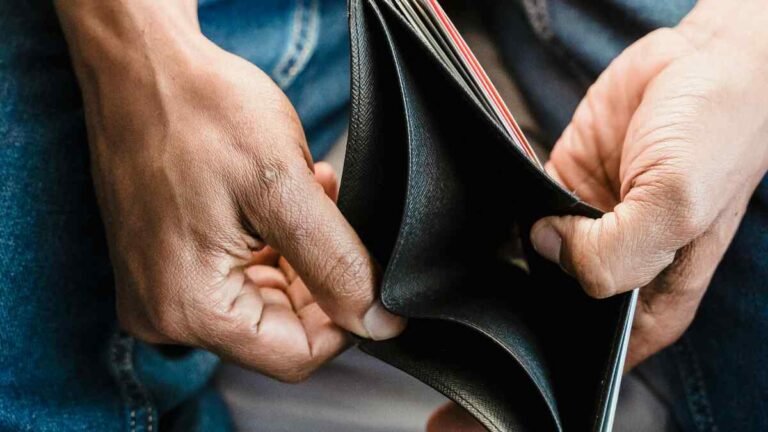Man holding wallet Toxic Money Habits