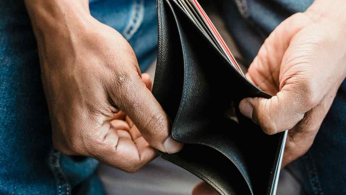 Man holding wallet Toxic Money Habits