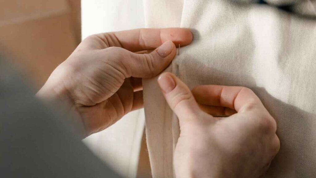 Repairing and mending clothes by hand to extend their life and reduce waste