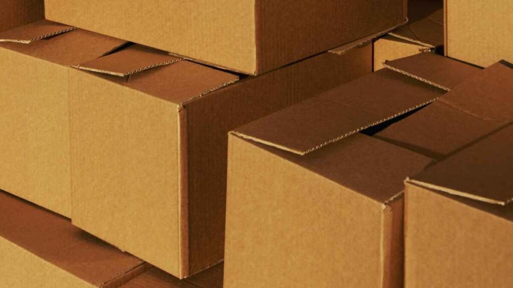 Stack of brown cardboard moving boxes representing moving to lower rent when living paycheck to paycheck