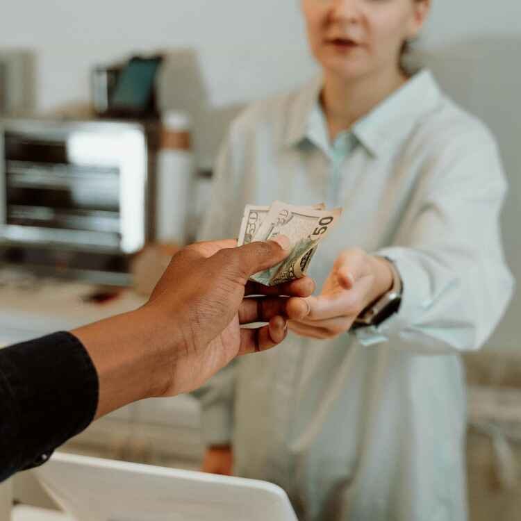Person paying for groceries using cash from an envelope budgeting system.